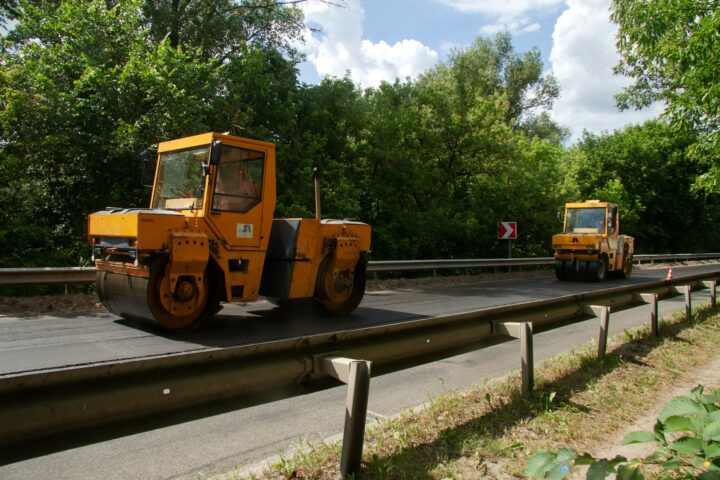 Dwa walce drogowe na świeżo położonym asfalcie przy budowie drogi