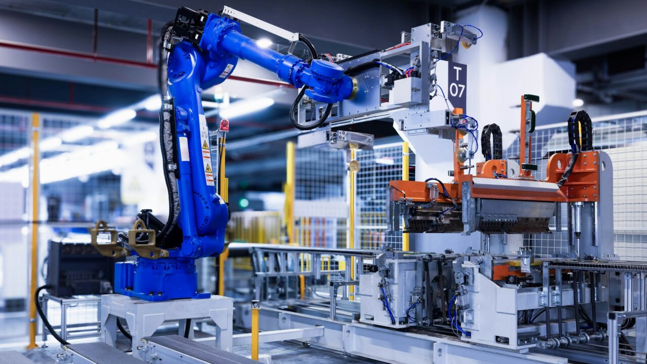 Niebieskie ramię robota przemysłowego na hali produkcyjnej