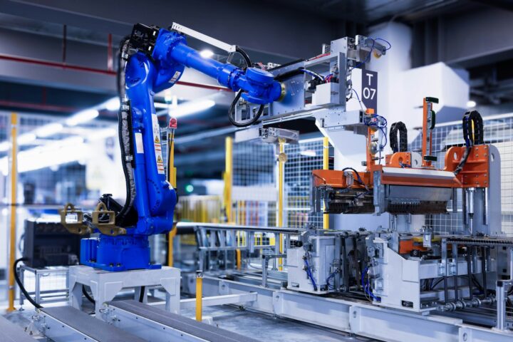 Niebieskie ramię robota przemysłowego na hali produkcyjnej
