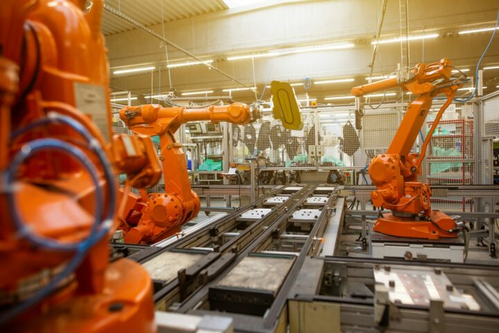Nowoczesna fabryka z rzędami pomarańczowych robotów przemysłowych