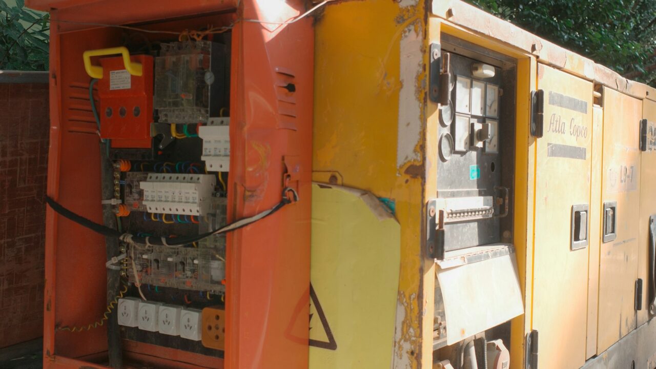 Przemysłowy agregat prądotwórczy z otwartą szafą elektryczną