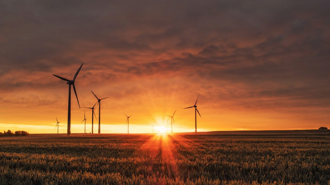 Turbina wiatrowa na polu w złotym świetle zachodu słońca